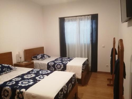a bedroom with two beds and a window at Portela - APARTAMENTO in Viana do Castelo