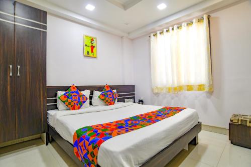 um quarto com uma cama grande e um cobertor colorido em FabHotel Grand Raj em Indore