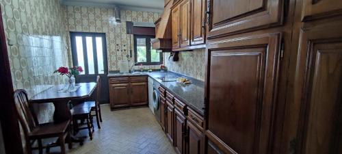 uma cozinha com armários de madeira e uma bancada em Casa da Rosa em Arcozelo