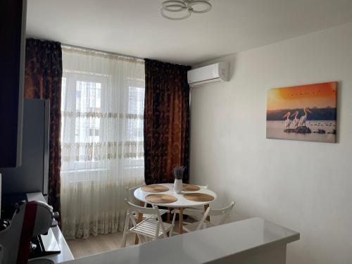 una stanza con un tavolo, delle sedie e una finestra di Apartament ELLA a Tulcea