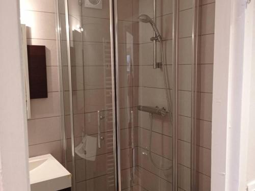 La salle de bains est pourvue d'une douche avec une porte en verre. dans l'établissement Appartement Méribel, 1 pièce, 2 personnes - FR-1-180-42, à Méribel