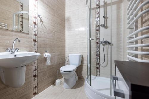 La salle de bains est pourvue d'un lavabo, de toilettes et d'une douche. dans l'établissement Willa Tatrzańska sauna balia w cenie, à Murzasichle