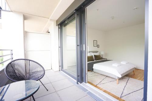 1 dormitorio con 1 cama, mesa y sillas en Green Garden Apartment w/.Balcony near Thermal Spa, en Viena