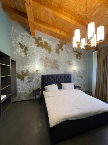 a bedroom with a large bed and a wooden ceiling at Pensiunea Casa Buna in Gîrbova