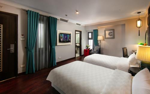a hotel room with two beds and green curtains at HOTEL du LAC Hanoi in Hanoi