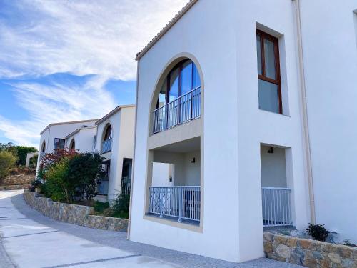 a white building with balconies on a street at La Listrella Residence & Spa in Monticello