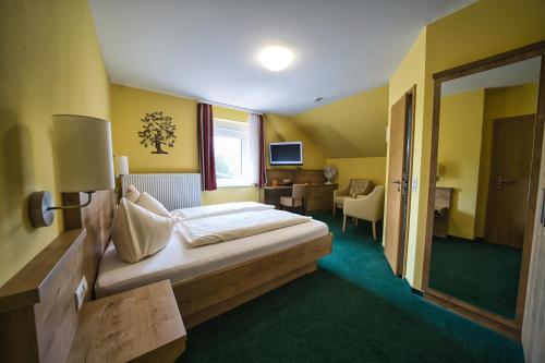 a hotel room with a bed and a living room at Hotel Tenner in Neustadt an der Weinstraße
