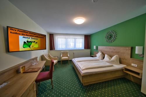 a hotel room with a large bed and a desk at Hotel Tenner in Neustadt an der Weinstraße