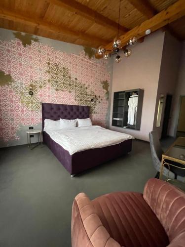 a bedroom with a large bed and a couch at Pensiunea Casa Buna in Gîrbova