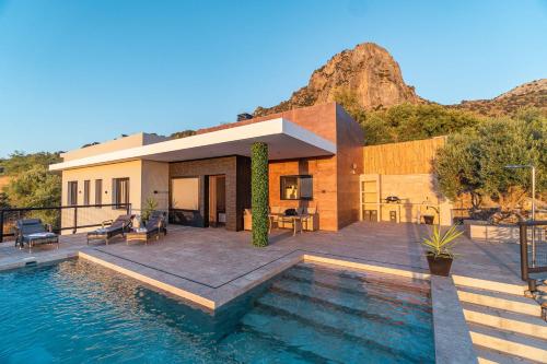 a house with a swimming pool in front of a house at Villa Fahrenheit in El Gastor