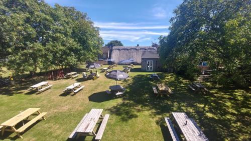 uma vista superior de um parque com mesas de piquenique e bancos em Five Bells Wickham em Newbury