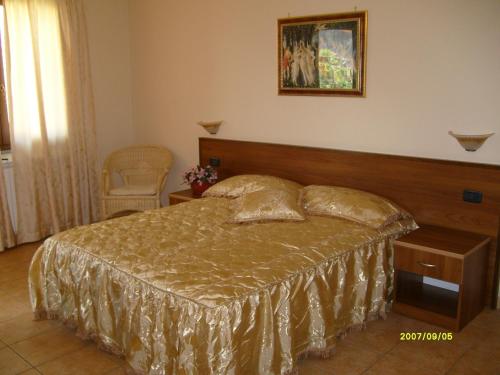 1 dormitorio con 1 cama y una foto en la pared en HOTEL RISTORANTE DEGLI AMICI, en Mongiana