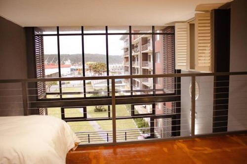 a bedroom with a large window with a view of a courtyard at Luxury Condo-loft Point Waterfront - Two bedroom plus Loft in Durban