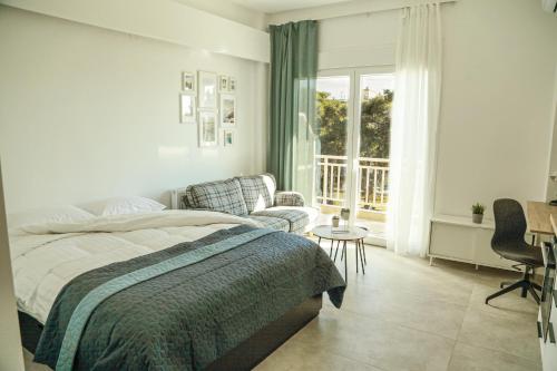 a bedroom with a bed and a chair and a window at Urban Apartments in Komotini