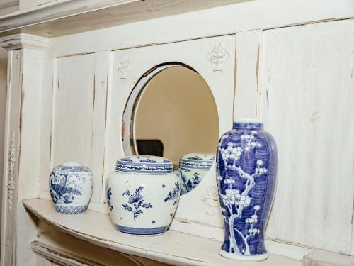 una mensola con tre vasi blu e bianchi e uno specchio di Twickenham Guest House a Johannesburg