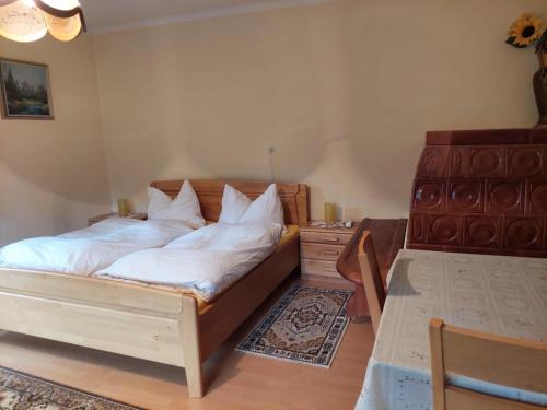 sypialnia z łóżkiem z białą pościelą i stołem w obiekcie Ferienwohnung Vertatschablick w mieście Ferlach