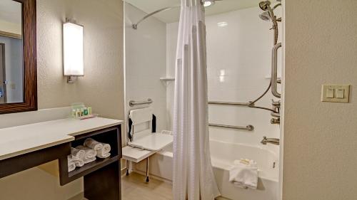 een badkamer met een douche, een wastafel en een toilet bij Holiday Inn & Suites Tupelo North, an IHG Hotel in Tupelo