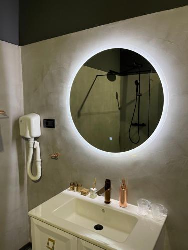 a bathroom with a white sink with a round mirror at Pensiunea Casa Buna in Gîrbova