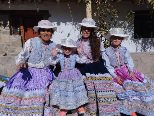 a group of women in traditional dress and hats at Casa vivencial Mamá Vivi in Coporaque