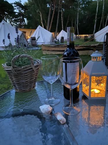 Una botella de vino y dos copas en una mesa. en Sielski Hel, en Hel