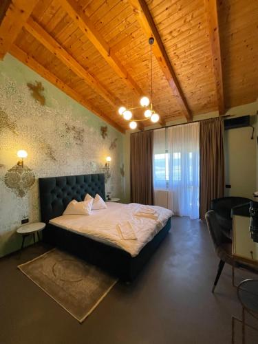 a bedroom with a large bed and a wooden ceiling at Pensiunea Casa Buna in Gîrbova
