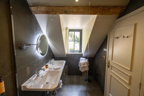 ein Bad mit einem Waschbecken und einem Spiegel in der Unterkunft Hôtel du cirque et de la cascade in Gavarnie