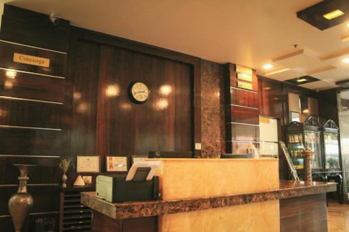 a cash counter in a store with a clock on the wall at Hotel Tea County in Dibrugarh