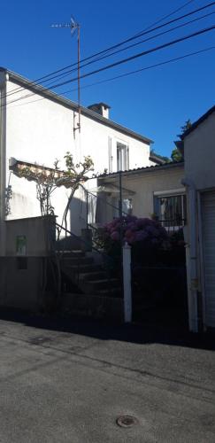 una casa con una escalera frente a un edificio en Le Mas Maison de village en Vabre