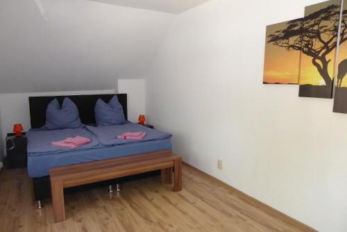 a bedroom with a blue bed and a painting at Stralsunder in Stralsund