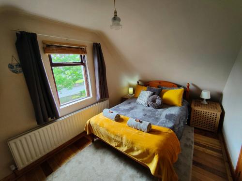a bedroom with a bed and a window at The Loft at Rowantree Cottage in Dromara