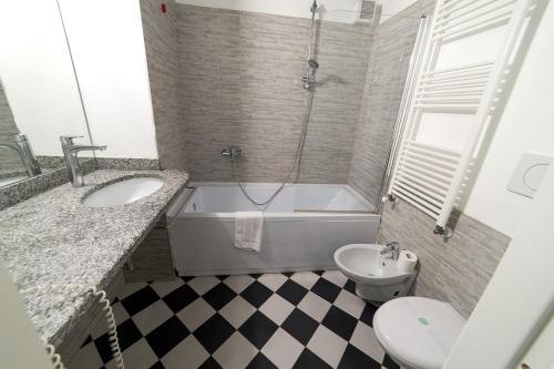 a bathroom with a tub and a sink and a toilet at Hbhall Residenze Darsena in Milan
