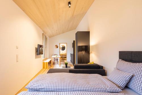 um quarto com uma cama e um sofá num quarto em am Greben Apartments eins - zwei - sechs - sieben em Bezau