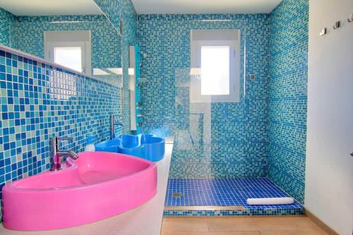 La salle de bains est pourvue d'un lavabo rose et d'une douche. dans l'établissement Casa del Sol, à Peñíscola