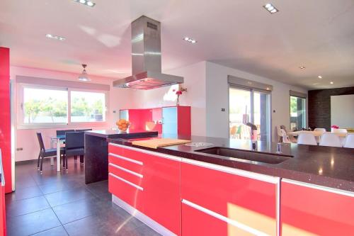 a kitchen with red cabinets and a black counter top at Casa del Sol in Peñíscola