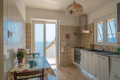 een keuken met een tafel en uitzicht op de oceaan bij Casa do Grifo - Incantevole appartamento con vista in Rovereto