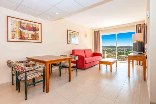 a living room with a red couch and a table at Valentin Grand Park Suite Hotel in Paguera