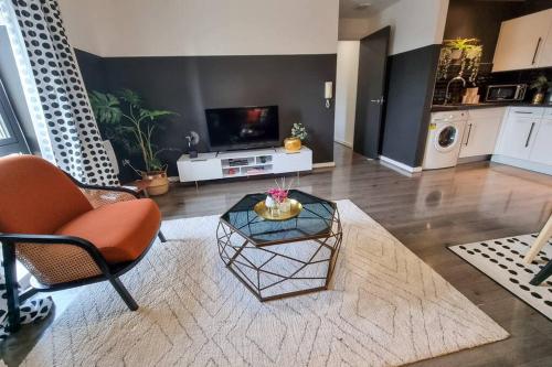 a living room with a chair and a table and a tv at Couples Retreat / Workers Paradise + Free Parking in Manchester