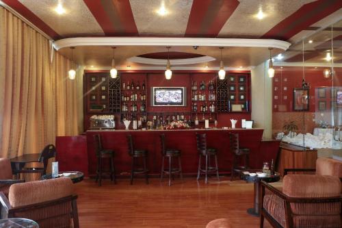 a bar in a restaurant with bar stools at Jupiter International Hotel - Bole in Addis Ababa