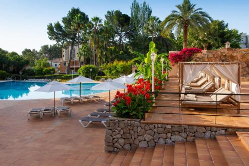 a resort with a pool and chairs and umbrellas at Valentin Grand Park Suite Hotel in Paguera