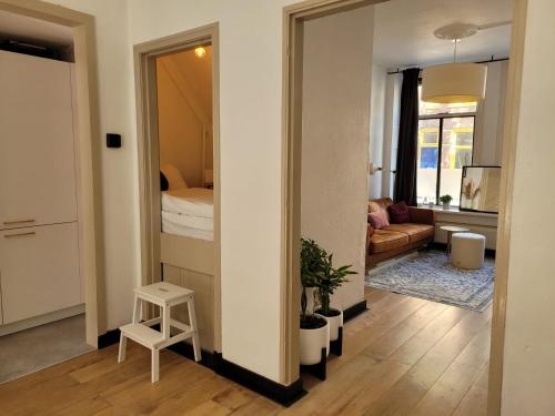 Habitación con pasillo con espejo y sala de estar. en Characteristic ground floor apartment with box bed en Groningen
