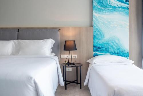 Una cama o camas en una habitación de Fortune Saeng Chan Beach Hotel Rayong - SHA Plus