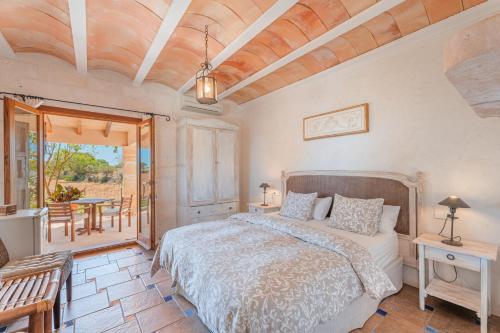 1 dormitorio con 1 cama, mesa y sillas en Finca Santigor, en Cala Ferrera