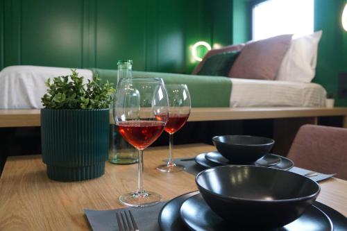 two glasses of wine on a table with a couch at Green Sunnyside Studio - Central Location in Bucharest