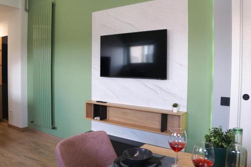 a living room with a tv and a table with wine glasses at Green Sunnyside Studio - Central Location in Bucharest