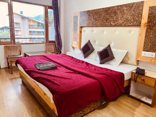 馬拉里的住宿－Hotel Solitaire - With Best View of Mountains，一间卧室配有一张带红色毯子的大床