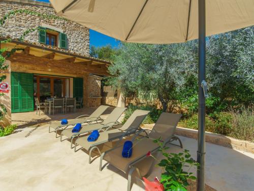a group of chairs and an umbrella on a patio at Holiday Home Can Marines des cami des carro by Interhome in S'Horta