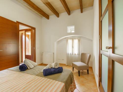 a bedroom with a large bed and a chair at Holiday Home Can Marines des cami des carro by Interhome in S'Horta