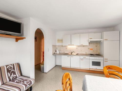 a kitchen with white cabinets and a table and chairs at Apartment Ratgebgut by Interhome in Zell am See