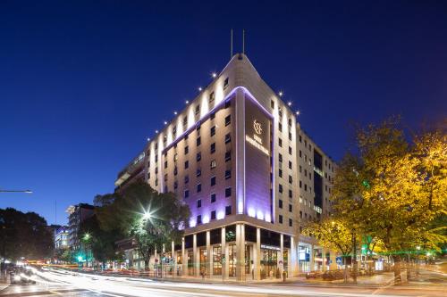 een verlicht gebouw in een stadsstraat 's nachts bij Hotel Marques De Pombal in Lissabon