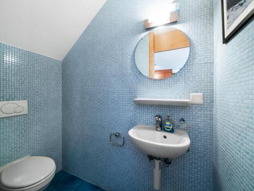 a blue tiled bathroom with a sink and a toilet at Apartment Apt C4-R - Résidence Bougainville by Interhome in Bouveret